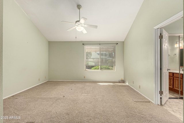 unfurnished bedroom with lofted ceiling, ensuite bathroom, a sink, carpet floors, and baseboards