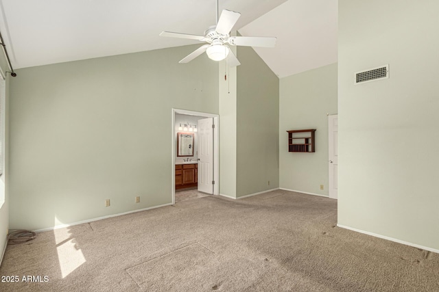 unfurnished bedroom with baseboards, light colored carpet, visible vents, and high vaulted ceiling