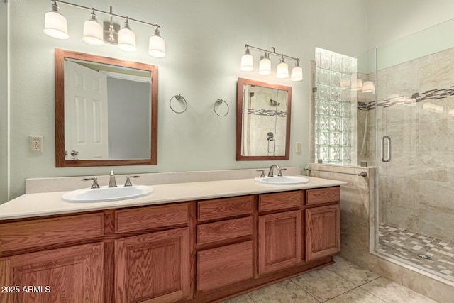 bathroom featuring a shower stall, double vanity, tile patterned floors, and a sink