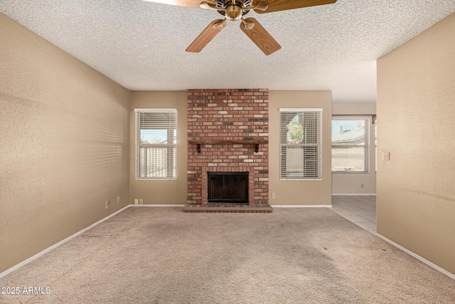 unfurnished living room with carpet flooring, a brick fireplace, a textured ceiling, and a textured wall