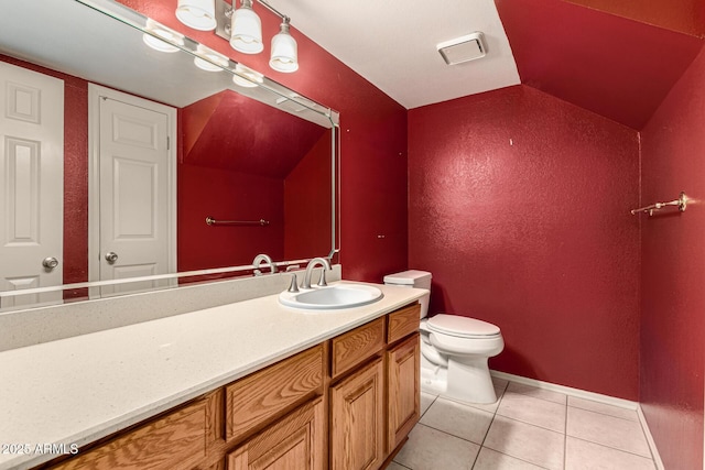 bathroom featuring vanity, baseboards, tile patterned flooring, vaulted ceiling, and toilet