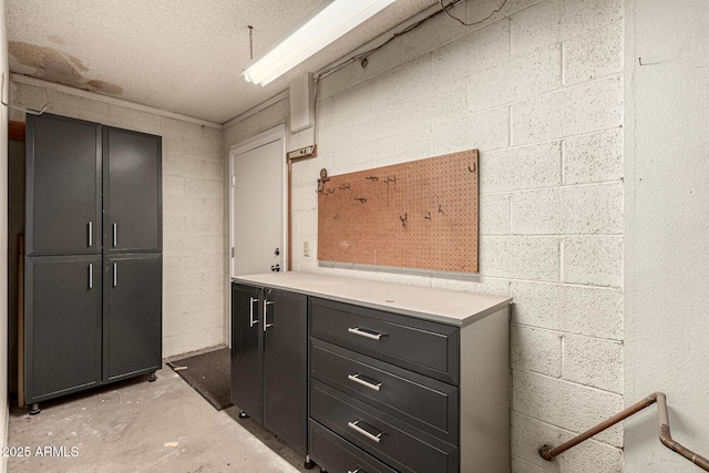 bathroom featuring concrete block wall, concrete floors, and a textured ceiling