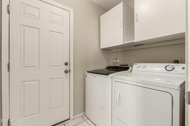 laundry room with light tile patterned floors, cabinet space, and washing machine and clothes dryer