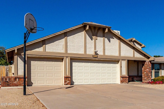 view of front of home featuring brick siding, stucco siding, an attached garage, and driveway