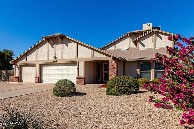 tudor house with a shingled roof, stucco siding, concrete driveway, a garage, and brick siding