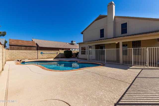 view of swimming pool with a patio, a fenced in pool, a fenced backyard, a diving board, and central AC