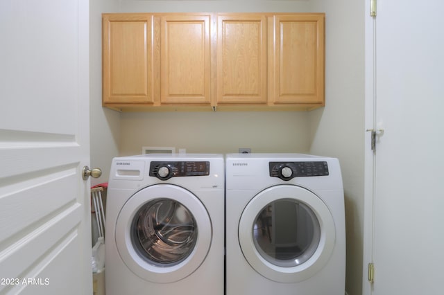 laundry room featuring cabinets and washer and clothes dryer