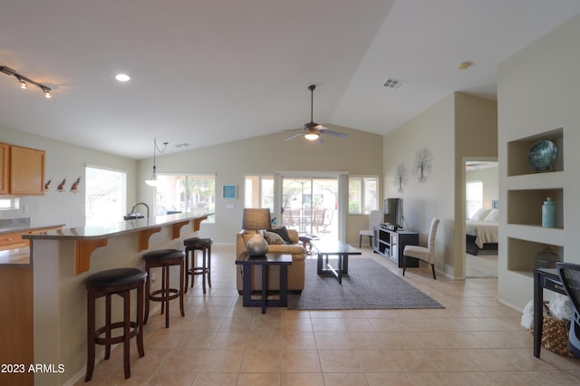 living room with vaulted ceiling, a healthy amount of sunlight, light tile patterned floors, and ceiling fan