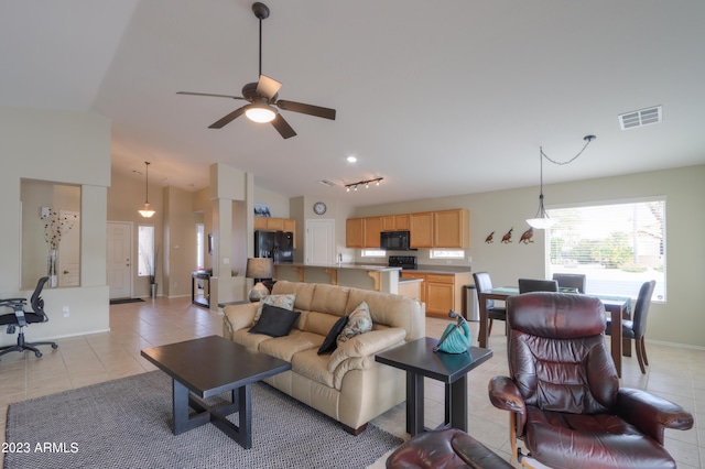 tiled living room with lofted ceiling and ceiling fan