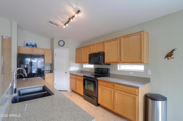 kitchen with sink, black appliances, light stone countertops, vaulted ceiling, and light brown cabinets