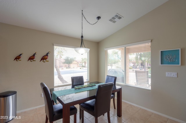 dining room with vaulted ceiling and light tile patterned floors