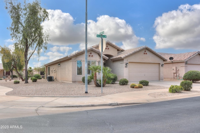 view of front of home with central AC and a garage