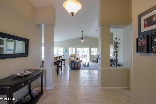 corridor featuring ornate columns, light tile patterned flooring, and lofted ceiling