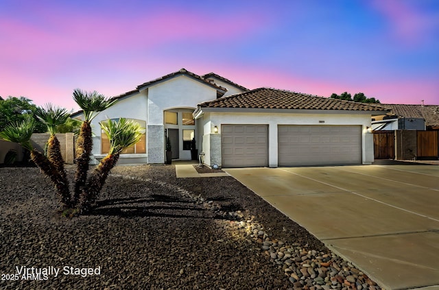 6935 W Monte Lindo St, Glendale, AZ 85310 - mediterranean / spanish house featuring a garage, stucco siding, concrete driveway, and a tiled roof