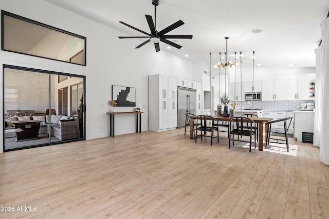6935 W Monte Lindo St, Glendale, AZ 85310 - dining space with a towering ceiling, a ceiling fan, light wood finished floors, a chandelier, and recessed lighting