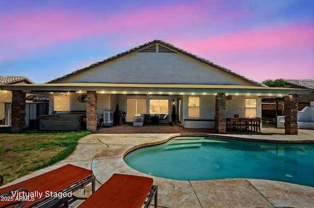 6935 W Monte Lindo St, Glendale, AZ 85310 - pool at dusk featuring a hot tub, a patio area, an outdoor hangout area, an outdoor pool, and outdoor dining area
