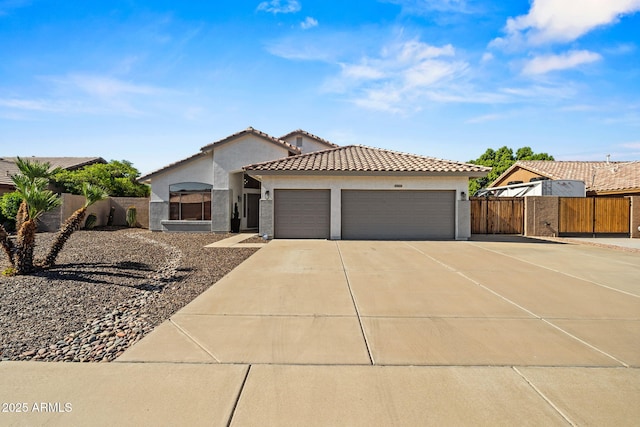 6935 W Monte Lindo St, Glendale, AZ 85310 - mediterranean / spanish home featuring stucco siding, an attached garage, concrete driveway, and a tiled roof