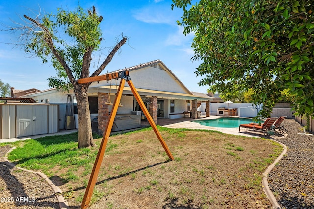 6935 W Monte Lindo St, Glendale, AZ 85310 - rear view of property featuring a hot tub, a storage unit, a fenced backyard, and a patio area