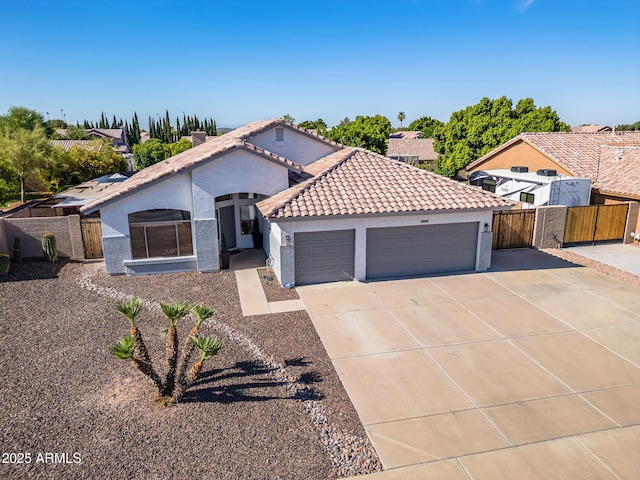 6935 W Monte Lindo St, Glendale, AZ 85310 - mediterranean / spanish house featuring a garage, stucco siding, concrete driveway, a tile roof, and a gate