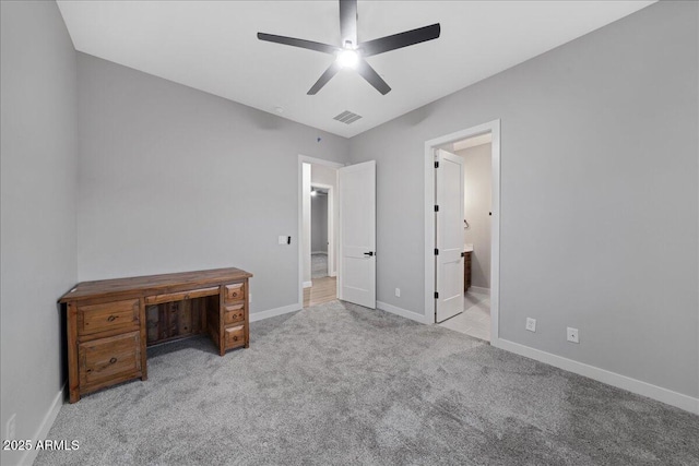 unfurnished bedroom with ceiling fan, light carpet, and connected bathroom