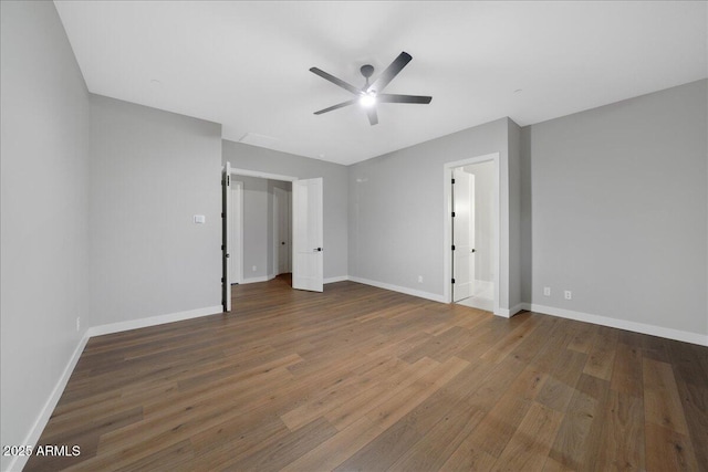 unfurnished bedroom with ceiling fan, dark wood-type flooring, and connected bathroom