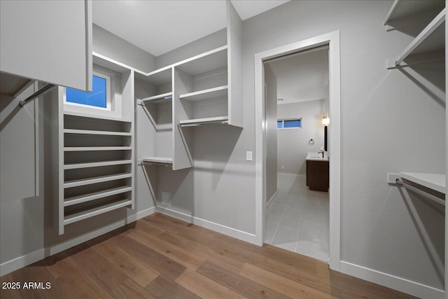 spacious closet with hardwood / wood-style floors