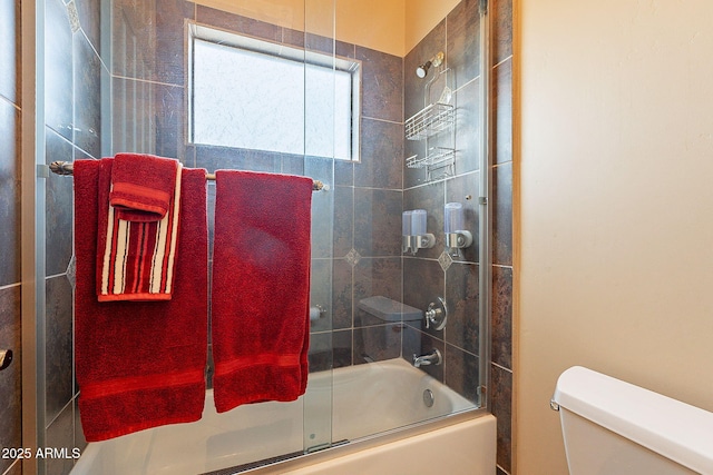 bathroom featuring toilet and combined bath / shower with glass door