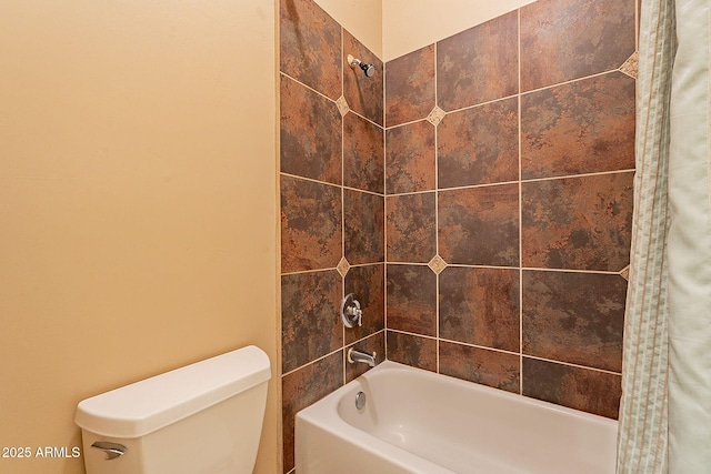 bathroom featuring tiled shower / bath and toilet