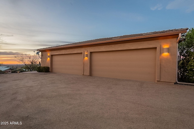 view of garage at dusk