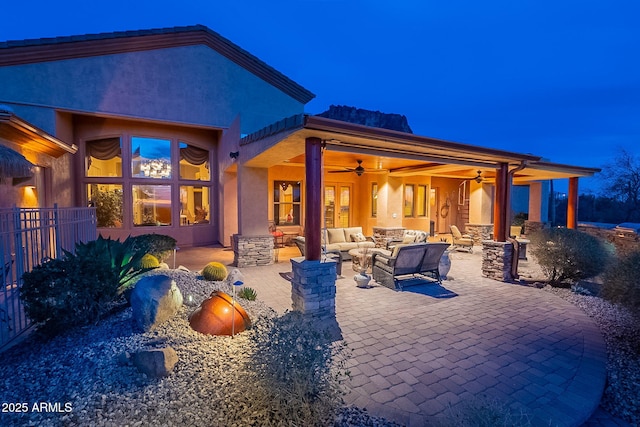 back of property featuring ceiling fan, an outdoor living space, and a patio area