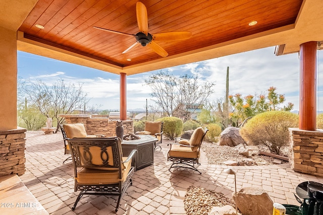 view of patio / terrace with an outdoor fire pit, ceiling fan, and exterior kitchen