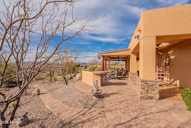 view of patio / terrace with exterior kitchen, an outdoor bar, and ceiling fan