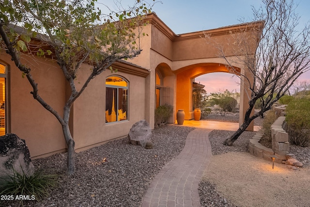 exterior entry at dusk with a patio