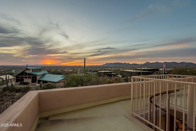 balcony at dusk featuring a mountain view