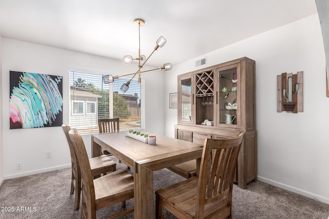 dining space with carpet flooring and a notable chandelier