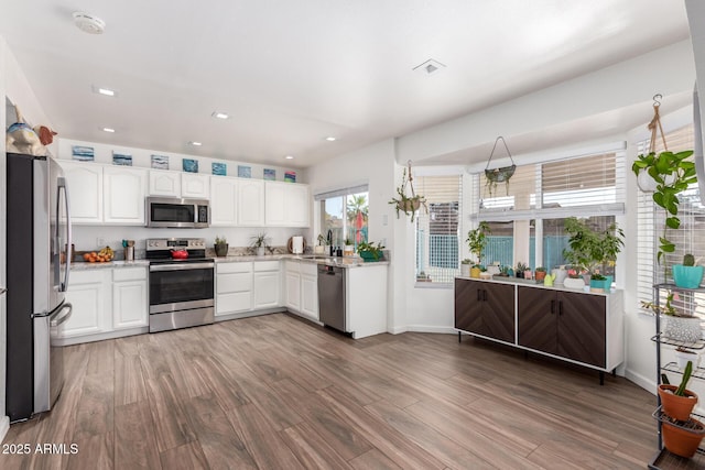 kitchen with white cabinetry, appliances with stainless steel finishes, sink, and dark hardwood / wood-style flooring