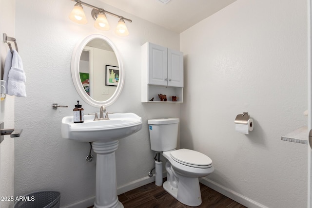 bathroom with toilet and hardwood / wood-style floors