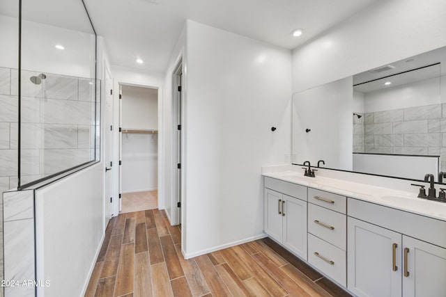 bathroom featuring a tile shower and vanity