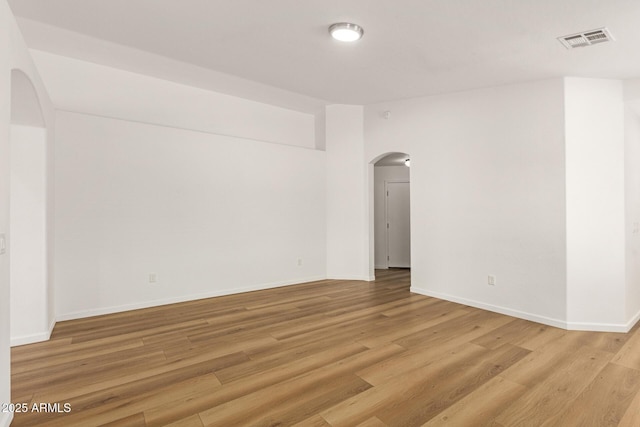 10212 E Caballero St, Mesa, AZ 85207 - empty room with arched walkways and light wood-style flooring