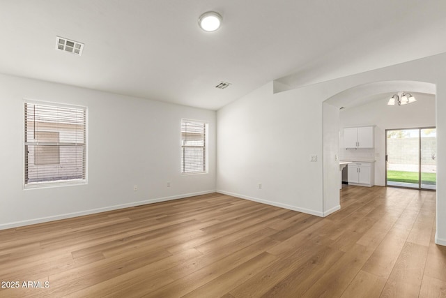 10212 E Caballero St, Mesa, AZ 85207 - unfurnished room with arched walkways, a chandelier, healthy amount of natural light, and light wood finished floors