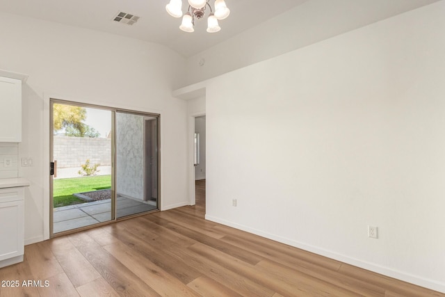 10212 E Caballero St, Mesa, AZ 85207 - empty room with light wood-style flooring, a chandelier, and high vaulted ceiling