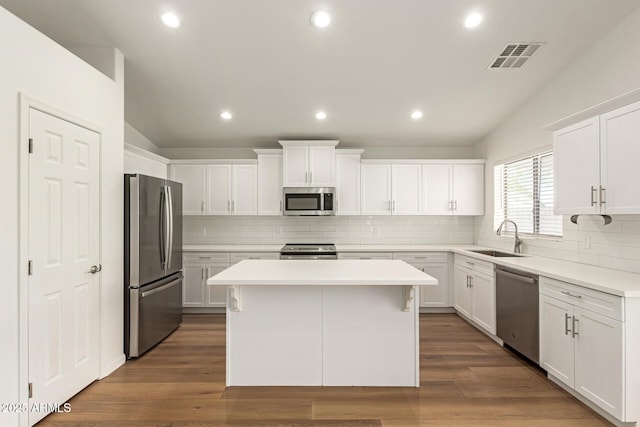 10212 E Caballero St, Mesa, AZ 85207 - kitchen with stainless steel appliances, a center island, backsplash, vaulted ceiling, and white cabinets