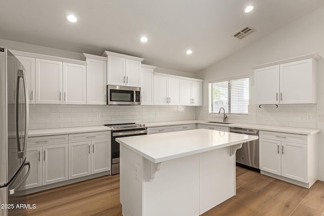 10212 E Caballero St, Mesa, AZ 85207 - kitchen with appliances with stainless steel finishes, white cabinets, tasteful backsplash, light wood-style flooring, and vaulted ceiling