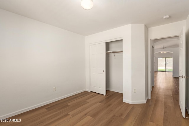 10212 E Caballero St, Mesa, AZ 85207 - unfurnished bedroom with wood finished floors, a closet, and arched walkways