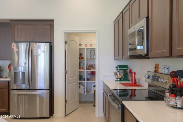 kitchen with light tile flooring and appliances with stainless steel finishes