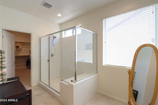 bathroom featuring a shower with shower door and tile flooring