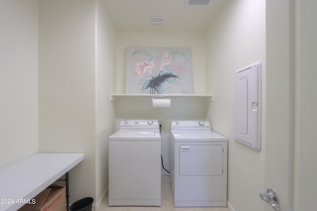 laundry room with washer and dryer and light tile floors