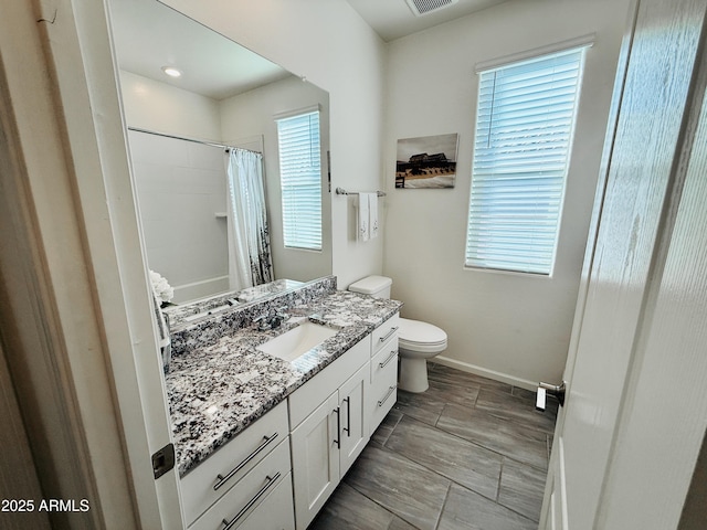 bathroom with baseboards, visible vents, a shower with shower curtain, toilet, and vanity