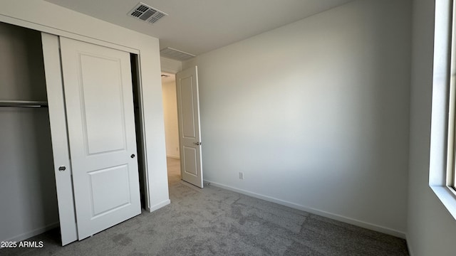 unfurnished bedroom with light carpet and a closet