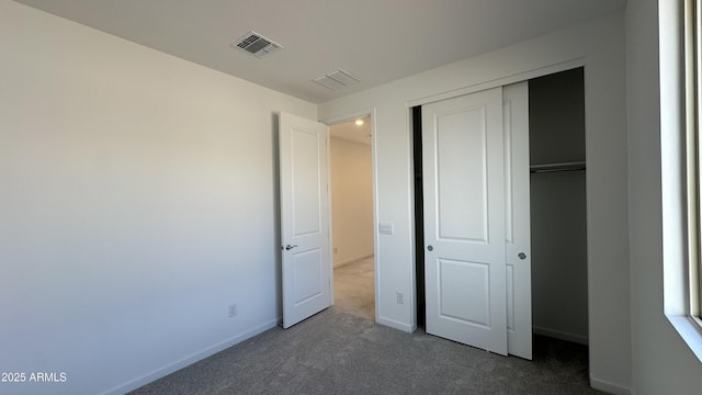 unfurnished bedroom with dark carpet and a closet